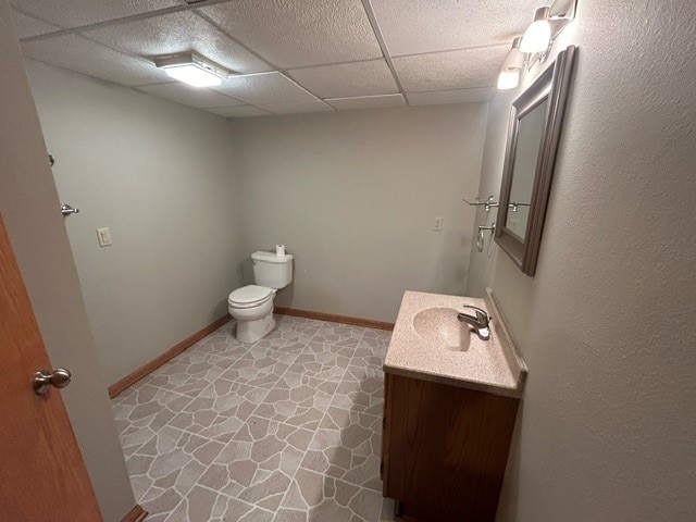 bathroom featuring a paneled ceiling, vanity, and toilet