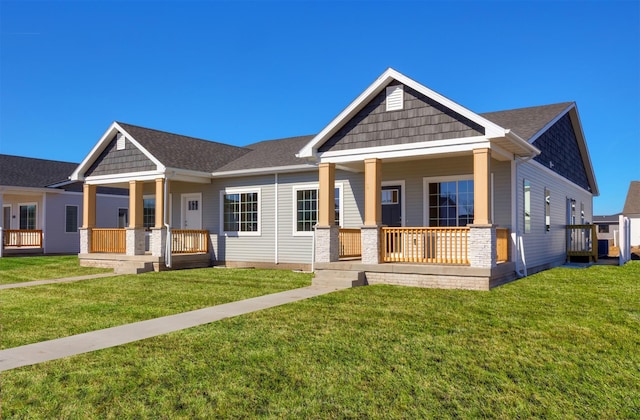 craftsman-style house with a porch, a front yard, and a shingled roof