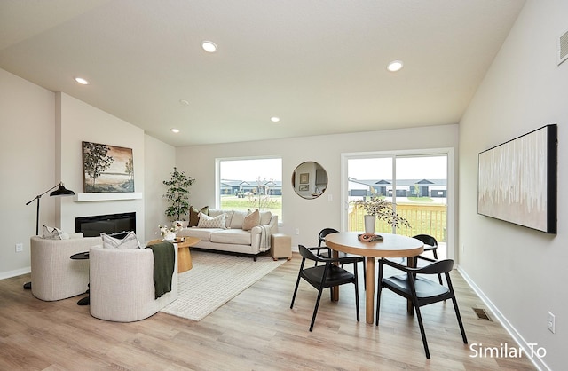 dining area featuring lofted ceiling and light hardwood / wood-style floors