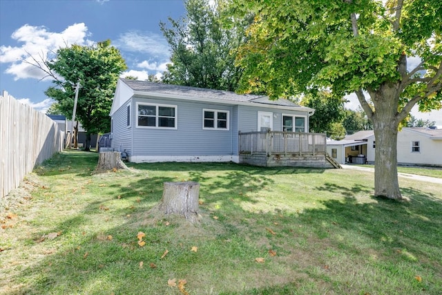 rear view of property with a lawn and a wooden deck