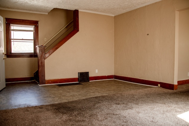 carpeted spare room featuring a textured ceiling and crown molding