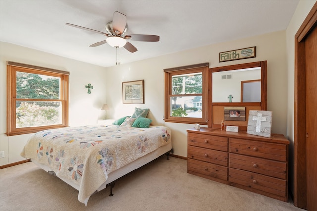 carpeted bedroom featuring ceiling fan and a closet