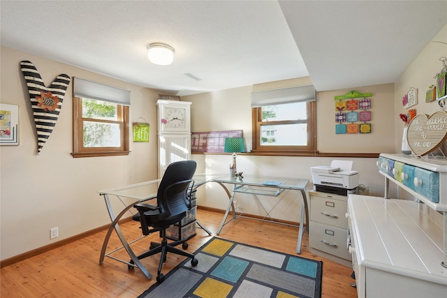 home office featuring a healthy amount of sunlight and light hardwood / wood-style floors