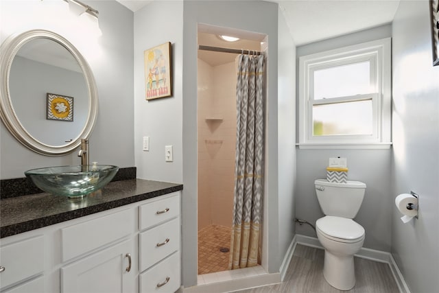 bathroom featuring walk in shower, hardwood / wood-style floors, vanity, and toilet