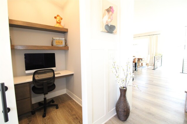 office featuring built in desk and light wood-type flooring