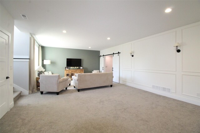 living room with light carpet and a barn door