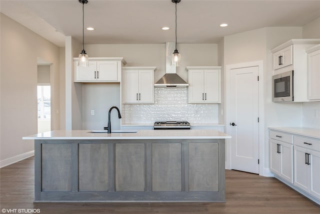 kitchen with sink, hanging light fixtures, and a center island with sink