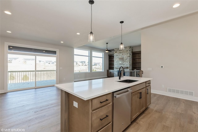 kitchen with ceiling fan, sink, light hardwood / wood-style flooring, dishwasher, and an island with sink