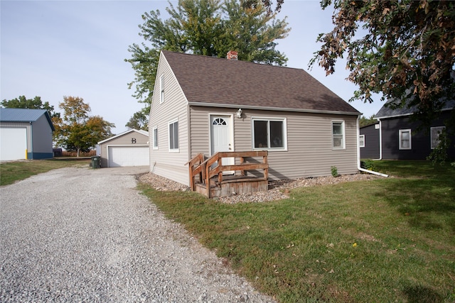 view of front of home featuring a garage, a front lawn, and an outdoor structure