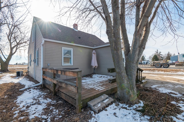 snow covered rear of property with a wooden deck