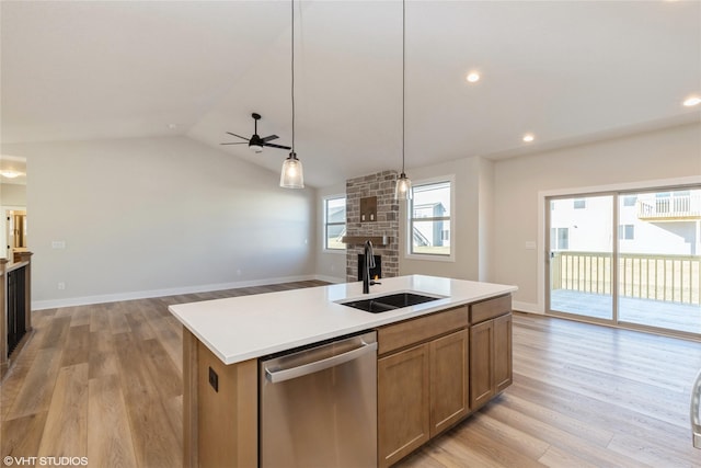 kitchen featuring sink, vaulted ceiling, ceiling fan, stainless steel dishwasher, and a center island with sink