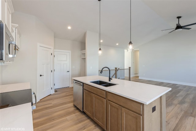 kitchen featuring sink, ceiling fan, an island with sink, hanging light fixtures, and appliances with stainless steel finishes