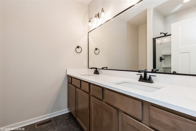 bathroom with a shower with shower door and vanity