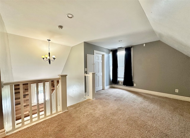 bonus room with carpet floors, lofted ceiling, and an inviting chandelier