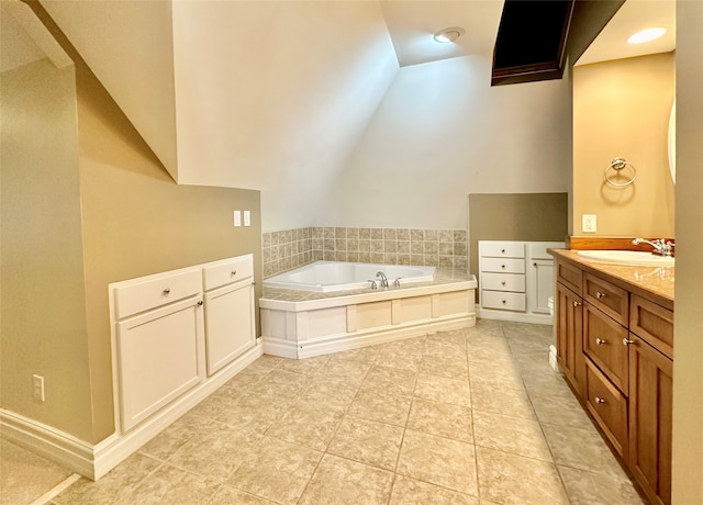 bathroom featuring vanity, a tub to relax in, vaulted ceiling, and tile patterned floors