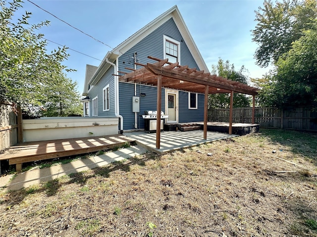 back of property with a pergola and a deck