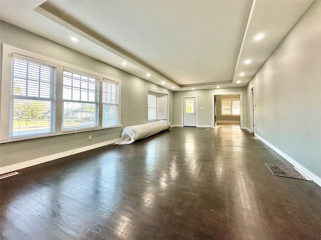 interior space featuring a raised ceiling and dark hardwood / wood-style flooring