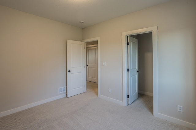 unfurnished bedroom featuring light carpet