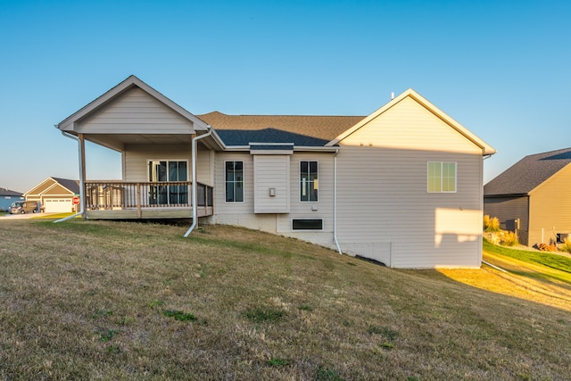 rear view of house featuring a lawn and a deck