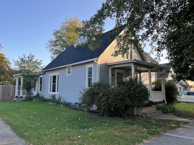 view of side of property with a lawn and a porch