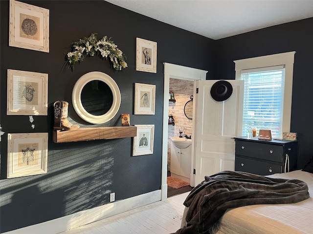 bedroom with connected bathroom and light hardwood / wood-style floors