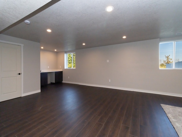 basement with a textured ceiling and dark hardwood / wood-style flooring