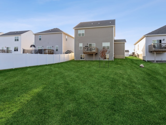 back of house with a lawn and a deck