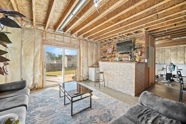 living room with bar area and concrete floors