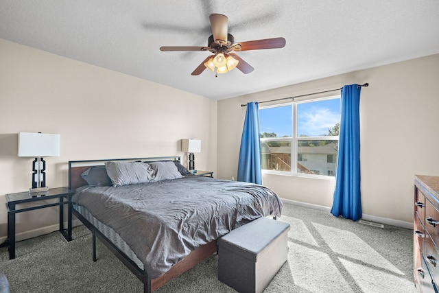 carpeted bedroom featuring ceiling fan and a textured ceiling