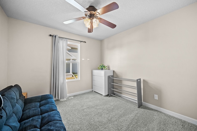 living area featuring ceiling fan, light colored carpet, and a textured ceiling