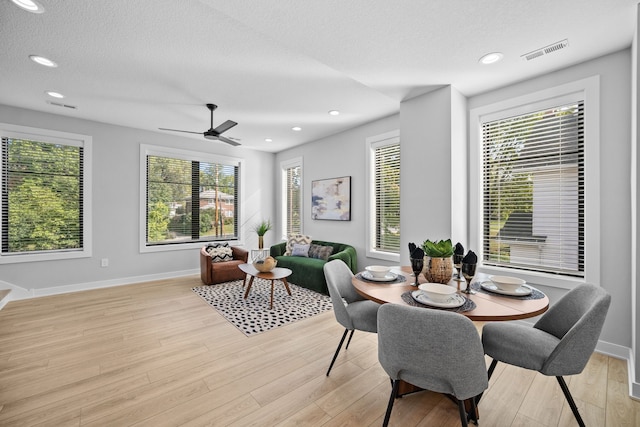 dining space with a textured ceiling, light wood-style flooring, visible vents, and recessed lighting