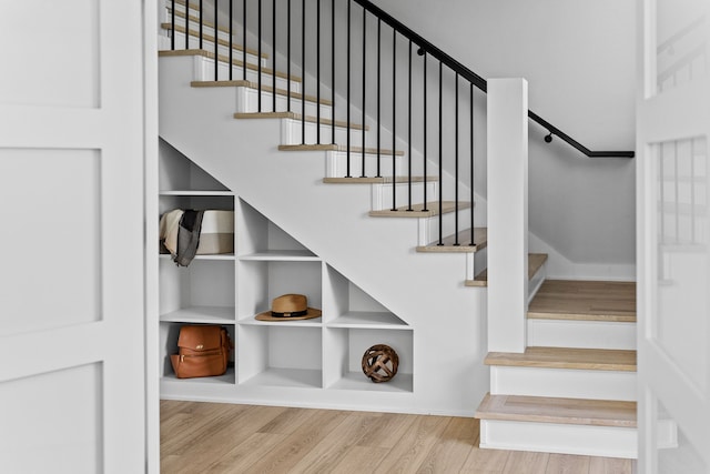 stairs with built in features and wood finished floors