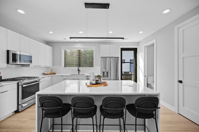 kitchen featuring stainless steel appliances, a center island, and light countertops