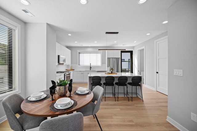 dining space with visible vents, baseboards, light wood-style flooring, and recessed lighting