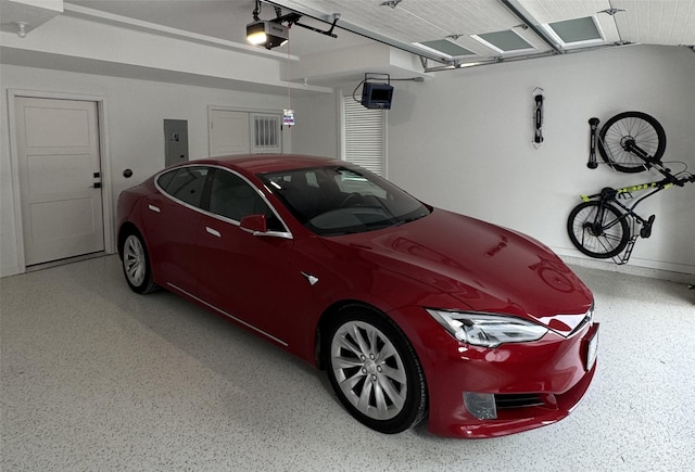 garage with a garage door opener and electric panel