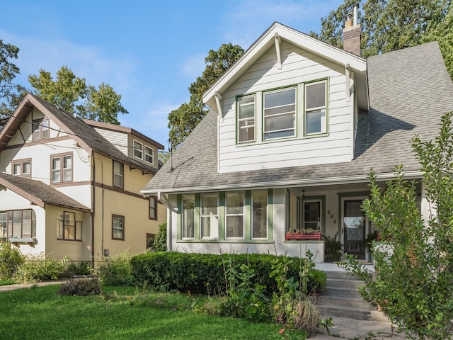 view of front of property with a front yard, a sunroom, and a porch