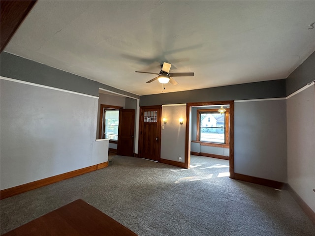 carpeted spare room with ceiling fan