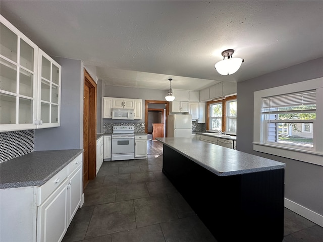 kitchen with tasteful backsplash, sink, white cabinetry, hanging light fixtures, and white appliances