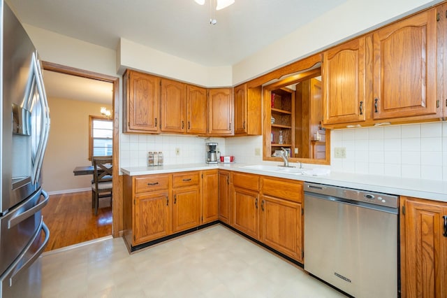 kitchen featuring stainless steel appliances, light hardwood / wood-style flooring, tasteful backsplash, and sink