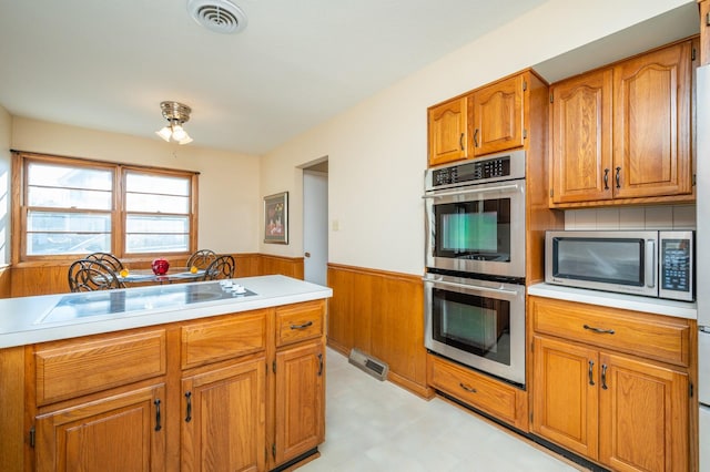 kitchen with wood walls, sink, and appliances with stainless steel finishes