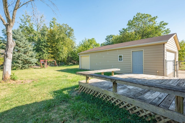 view of yard featuring a garage, an outbuilding, and a playground