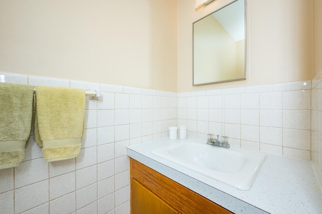 bathroom featuring vanity and tile walls