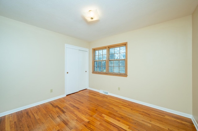 unfurnished room with hardwood / wood-style flooring