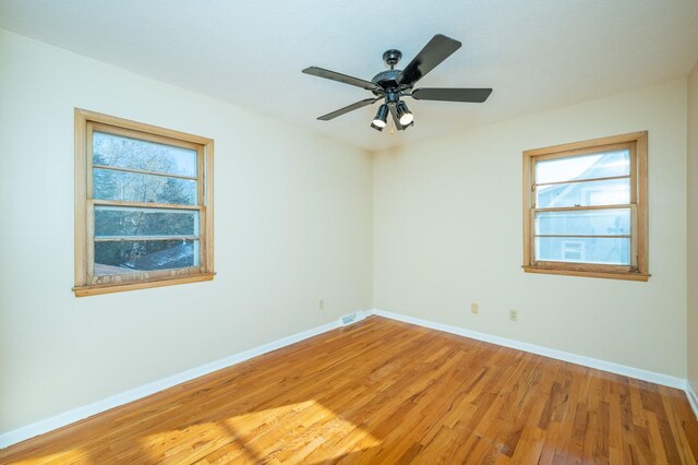 unfurnished room with hardwood / wood-style flooring and ceiling fan