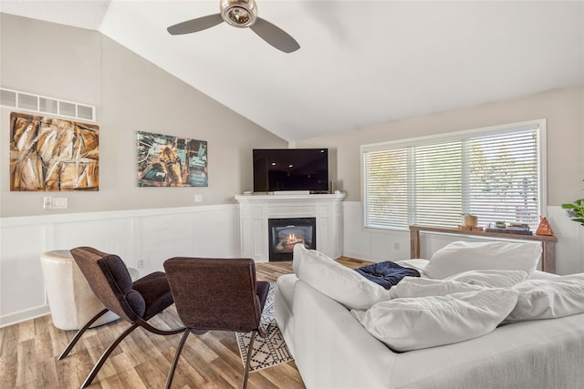 living room featuring light hardwood / wood-style floors, lofted ceiling, and ceiling fan