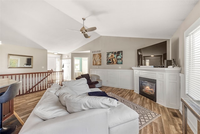 living room featuring ceiling fan, light hardwood / wood-style flooring, vaulted ceiling, and a wealth of natural light