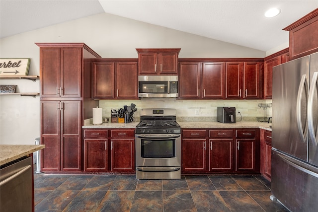 kitchen with appliances with stainless steel finishes, decorative backsplash, vaulted ceiling, and light stone countertops