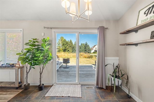 doorway to outside with an inviting chandelier