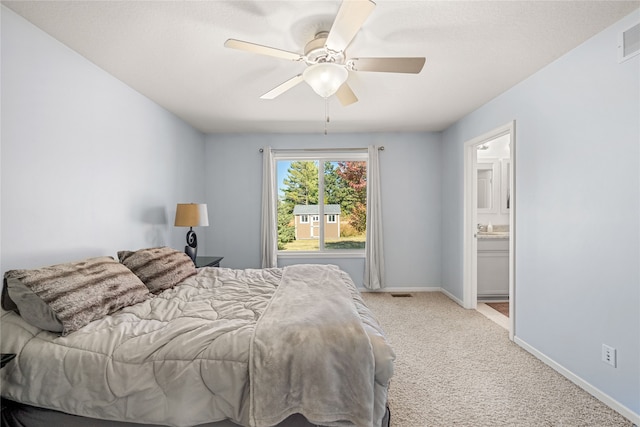 bedroom featuring ceiling fan, ensuite bath, and light carpet