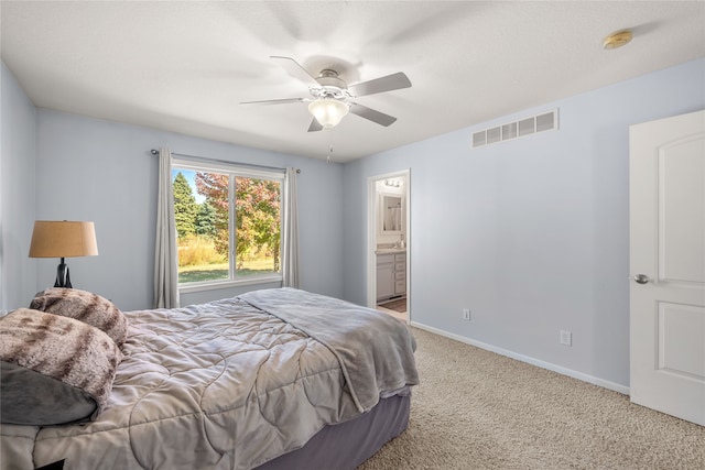 bedroom with light carpet, ceiling fan, and ensuite bathroom